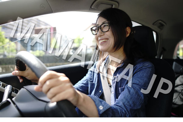 運転するメガネをかけた笑顔の女性