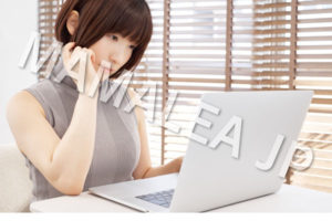 パソコンを見て悩む女性