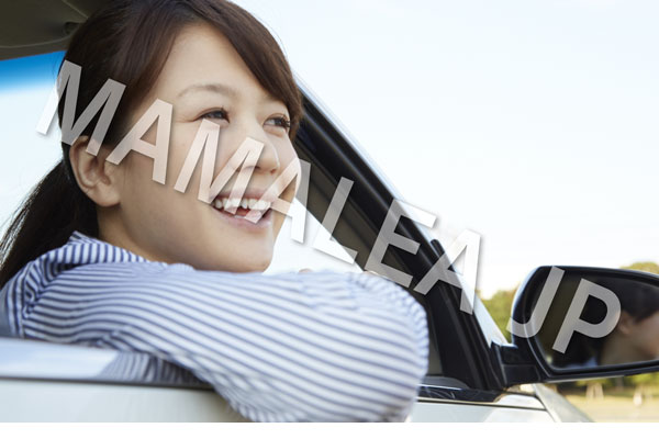 車の窓から顔を出す笑顔の女性