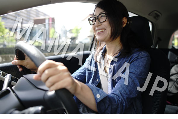 笑顔で運転するメガネの女性